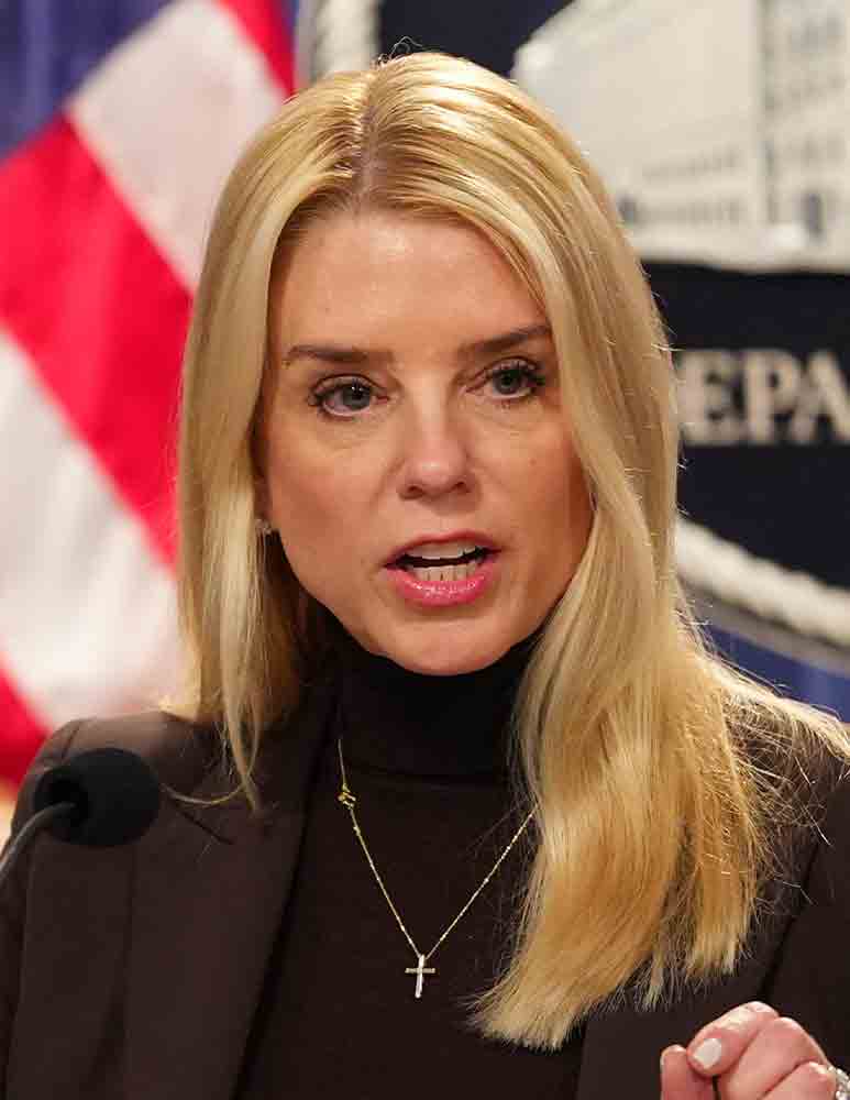 Pam Bondi speaking at DOJ podium in 2025, amid gun registry controversy - official portrait with American flag background