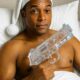 Satirical 2025 image of Don Lemon gun hypocrisy: Former CNN host in bed with nightcap, holding ice cube water pistol as absurd symbol of arming Black communities against ICE raids and Second Amendment flip-flop.