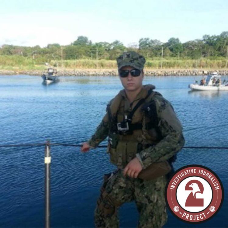 Adamiak_3 - Freedom’s Lodge Soldier in camouflage gear and sunglasses standing by a railing on a waterfront, with boats and a shoreline in the background.